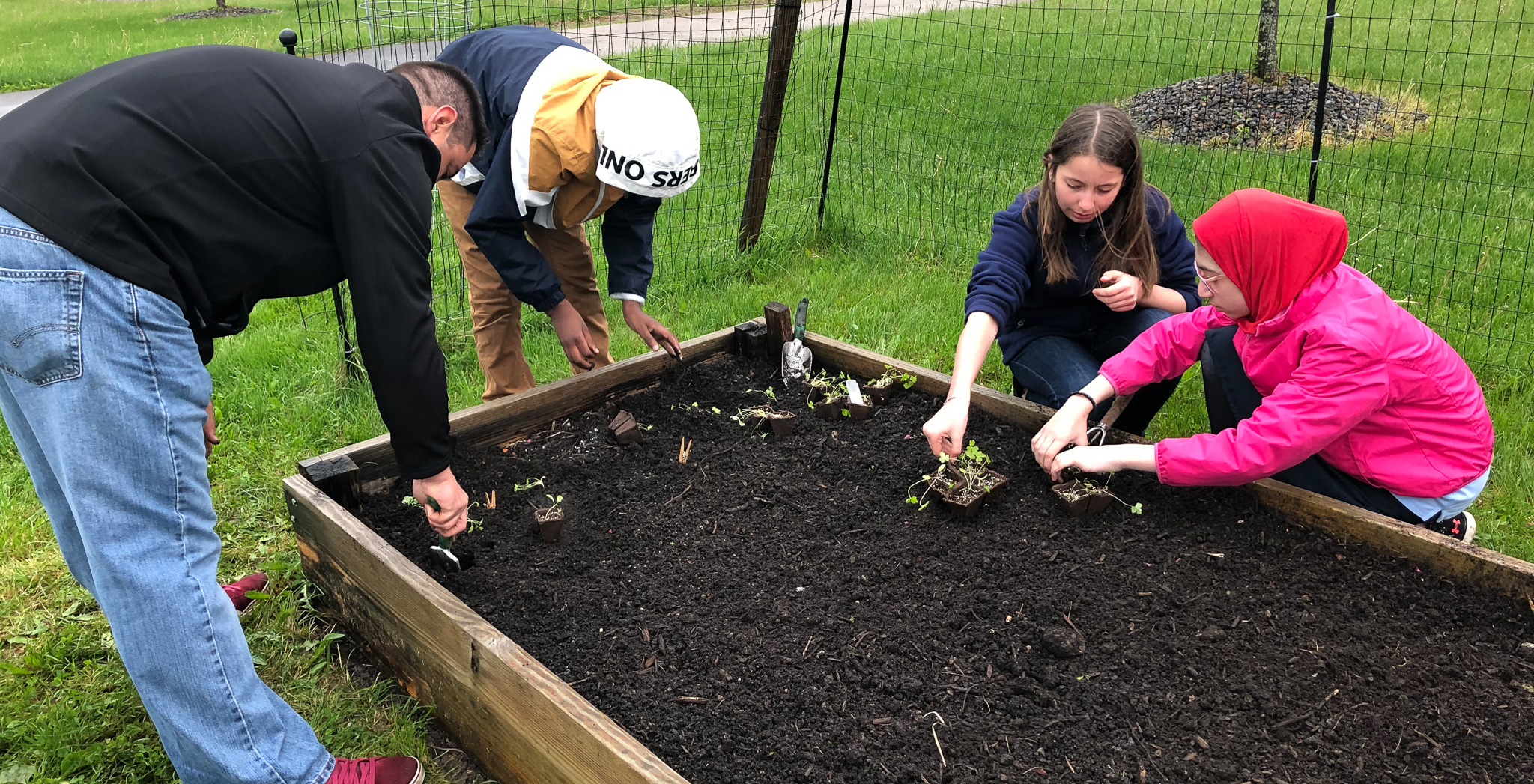 UASCS Atoms work with veterans to plant vegetables in their garden through Sitrin Health Care Center's Military-Civilian Coalition program